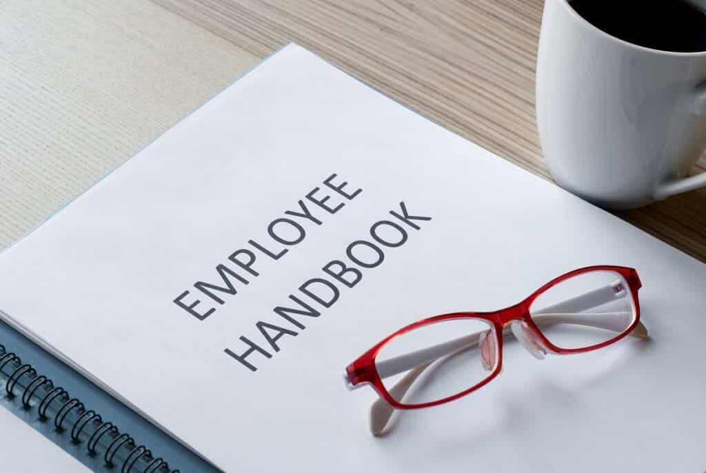 Business owner reviews employee manual and handbook for business