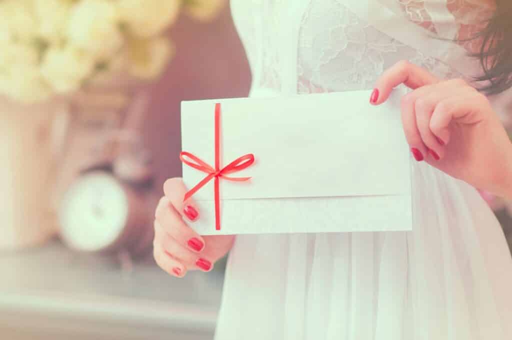 Woman happily holding holiday greeting card from small business